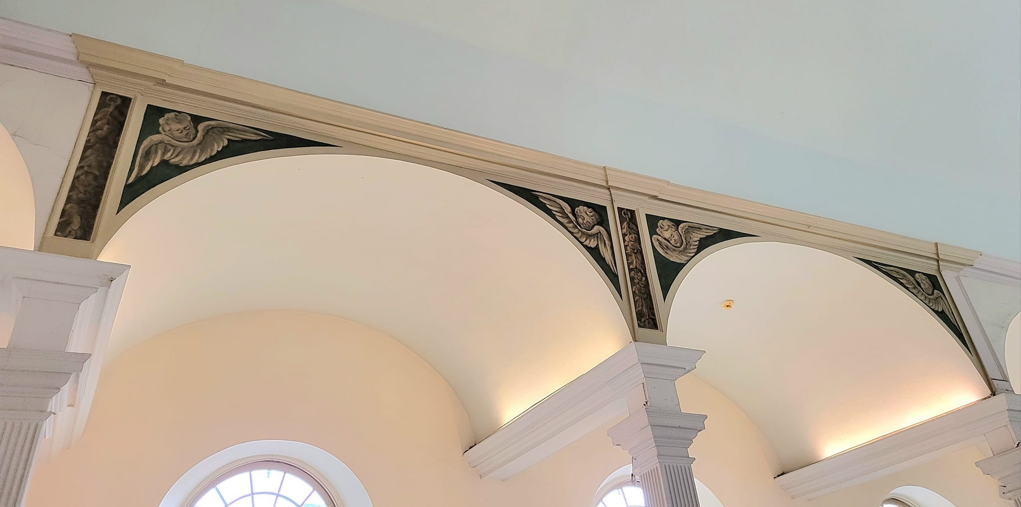 Four cherubs in Old North Church's balcony arches.