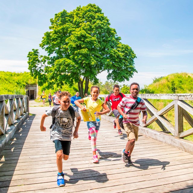 Kids running across a bridge at the Boston Harbor Islands. 