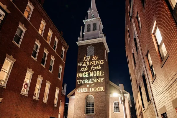 A projection onto the Old North Church by Silence Dogood that reads: "Let the Warning ride forth Once More Tyranny is at our Door."
